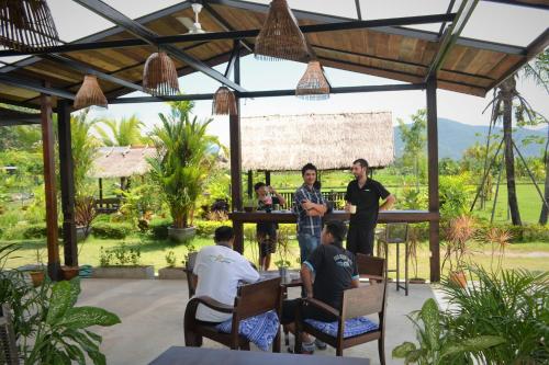 a group of people sitting around a table in a pavilion at Le Cocotier in Ban Cho Lae