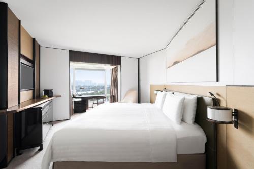 a hotel room with a large bed and a window at Shangri-La Singapore in Singapore