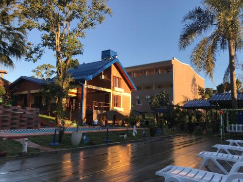 a building with white lounge chairs in front of it at Hotel Amayal in Puerto Iguazú