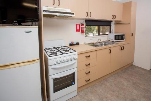 a kitchen with a white stove and a sink at BIG4 Shepparton Park Lane Holiday Park in Shepparton