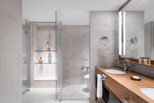 a bathroom with a glass shower and two sinks at Shangri-La Singapore in Singapore