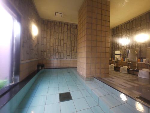 a swimming pool in a bathroom with sinks and mirrors at Hotel Route-Inn Kikugawa Inter in Kikugawa