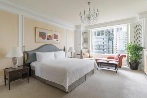 a bedroom with a large bed and a chandelier at Shangri-La Singapore in Singapore
