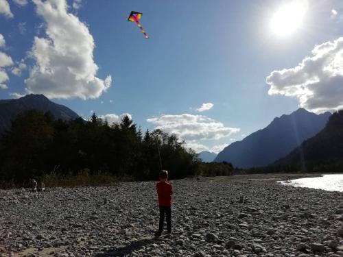 a man flying a kite on a rocky beach at Apart Lechtraum in Stanzach