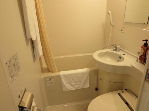 Baño pequeño con lavabo y aseo en Hotel Route-Inn Kikugawa Inter, en Kikugawa