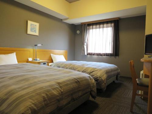 Tempat tidur dalam kamar di Hotel Route-Inn Kikugawa Inter