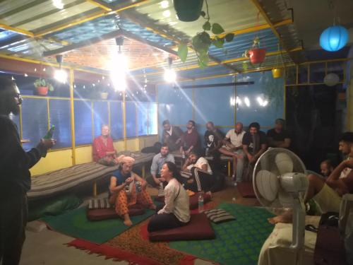 a group of people sitting in a room at The Little Blue Window Hostel in Bengaluru