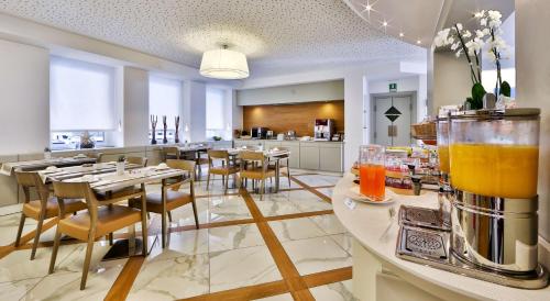 a restaurant with tables and chairs and a kitchen at Best Western Hotel City in Milan
