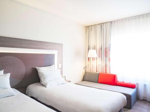 a hotel room with two beds and a window at Novotel Katowice Centrum in Katowice