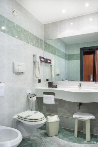 a bathroom with a toilet and a sink and a tub at Point Hotel in Piove di Sacco