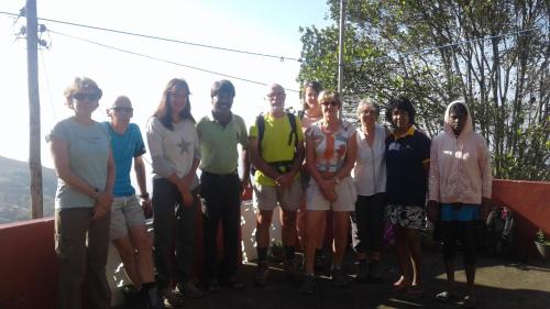 a group of people posing for a picture on a mountain at The Mist Holiday Bungalow in Haputale