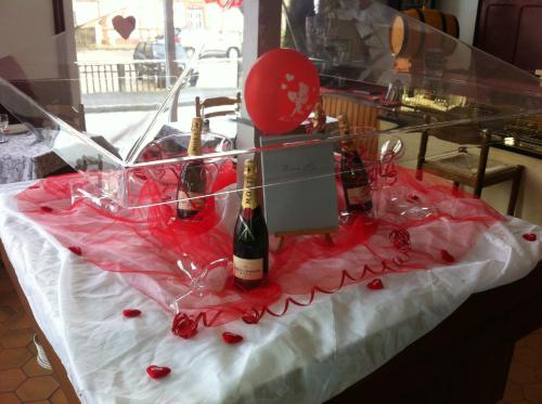 a table with two bottles of wine in a display case at Hotel De La Gare in Sainte-Gauburge-Sainte-Colombe