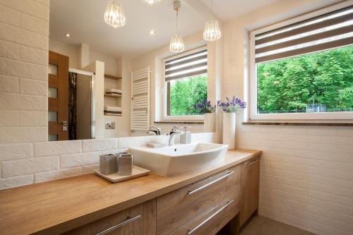 a bathroom with a sink and a large mirror at Apartamenty Home Sweet Home Na Górnej in Szklarska Poręba
