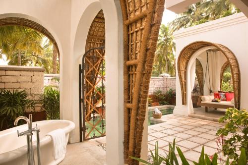 a bathroom with a tub and an outdoor patio at Taj Bekal Resort & Spa, Kerala in Bekal