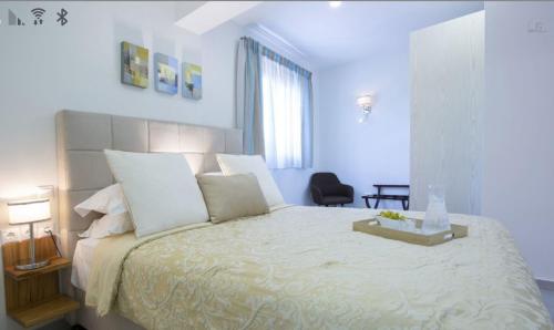 a white bedroom with a large bed with white pillows at Villa Del Mar in Vasiliki