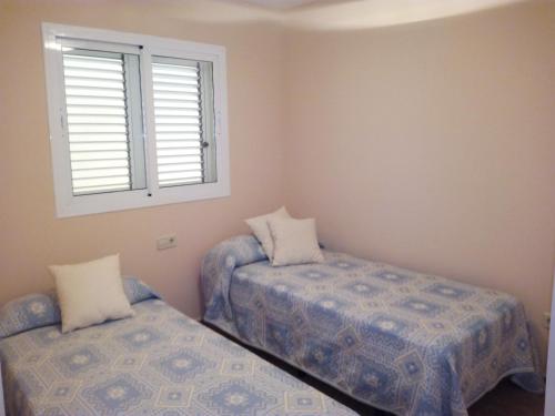 - une chambre avec 2 lits et une fenêtre dans l'établissement Apartmento playa Almarda. Piscina&Parking, à Almardá