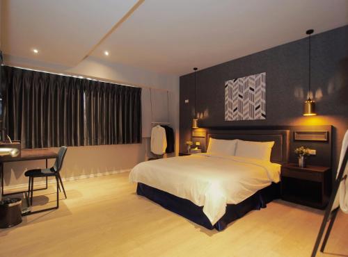 a bedroom with a bed and a desk and a bed sidx sidx sidx at Anson 19 B&B in Lugang
