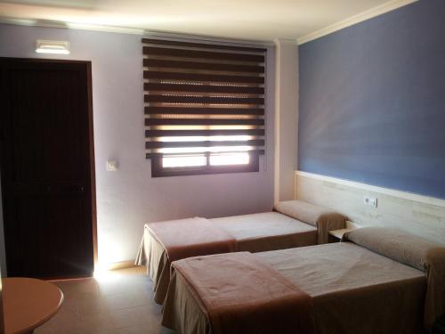 two beds in a room with a window at La Brisa de Tarik Rooms in Tarifa