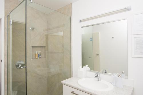 
a bathroom with a shower, sink, and mirror at Abel Tasman Lodge in Marahau
