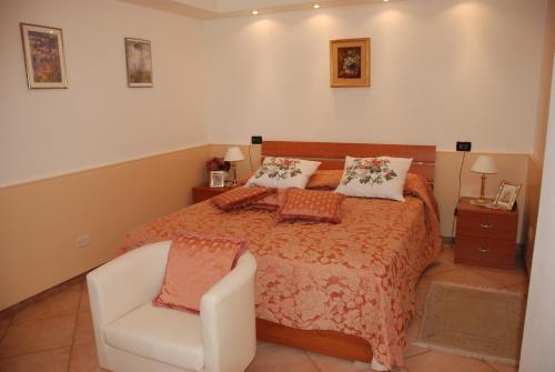 a bedroom with a bed and a white chair at Casa Fantasia in Tremezzo