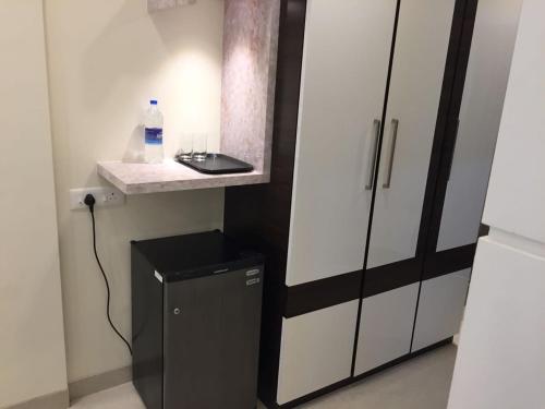 een kleine koelkast in een kamer met een aanrecht en een fles water bij Hotel Rezo's in Baga