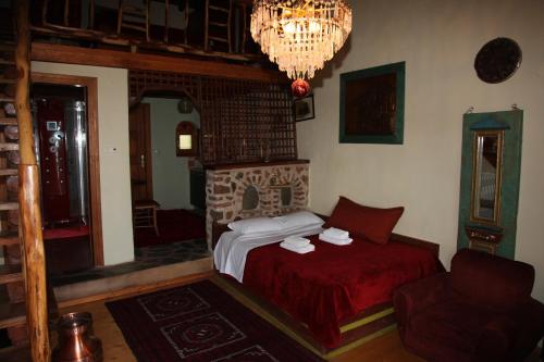 a bedroom with a bed and a fireplace and a chandelier at Iaspis Guesthouse in Kastoria