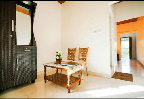 ein Wohnzimmer mit einem Tisch und 2 Stühlen in der Unterkunft Munnar Minds Homestay in Munnar