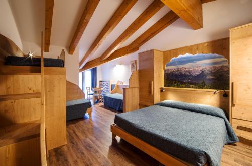 una camera con 2 letti e pareti in legno di Hotel Al Plan Andalo ad Andalo