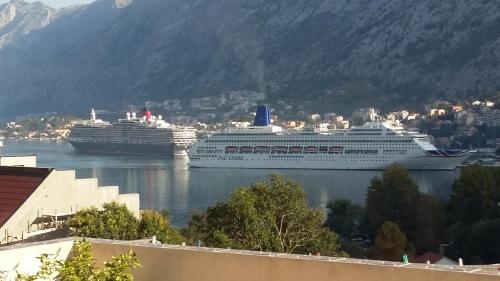 two cruise ships are docked in a harbor at Apartments Krivokapic in Kotor