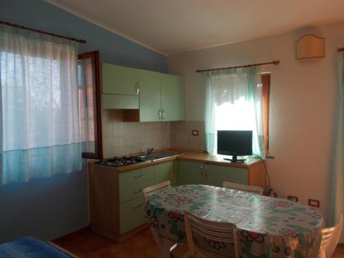 a kitchen with a table and a kitchen with a window at Agriturismo Ezzi Mannu in Stintino
