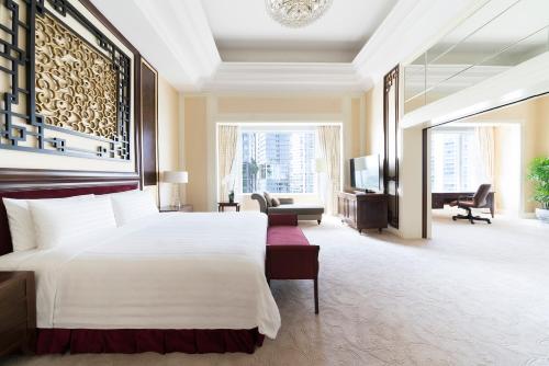a bedroom with a large bed and a living room at Shangri-La Singapore in Singapore