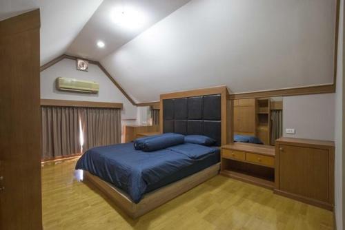 a bedroom with a large bed and a desk at Young Place in Bangkok