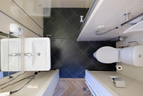 uma casa de banho com 2 lavatórios brancos e um espelho em Hotel Metropolis em Kaunas