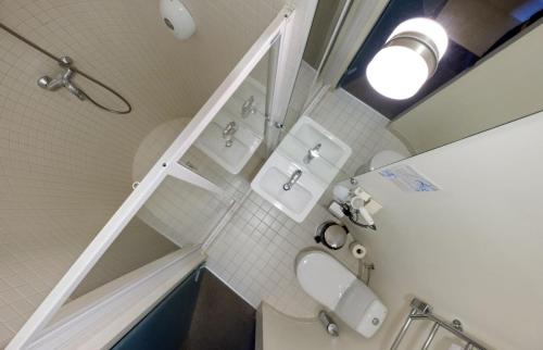 a bathroom with a shower and a sink and a mirror at Hotel Metropolis in Kaunas