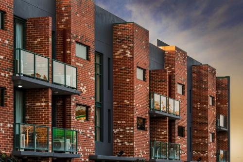 a brick building with a brick wall and windows at Perth Ascot Central Apartment Hotel in Perth