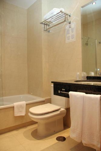 a bathroom with a toilet and a tub and a sink at Hotel Pradillo Conil in Conil de la Frontera
