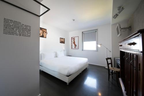 a white bedroom with a bed and a window at Aiden by Best Western JHD Dunant Hotel in Castiglione delle Stiviere