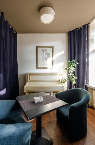 a living room with two chairs and a piano at Hotel Metropolis in Kaunas