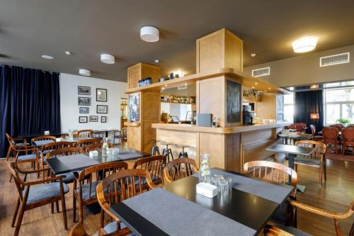 a restaurant with tables and chairs and a bar at Hotel Metropolis in Kaunas