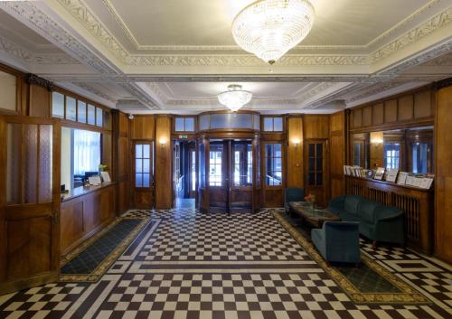 a lobby of a building with a checkered floor at Hotel Metropolis in Kaunas