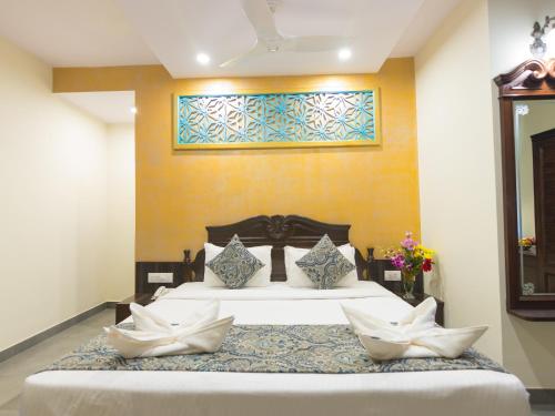 a hotel room with a large bed and a large window at Resort Terra Paraiso in Calangute