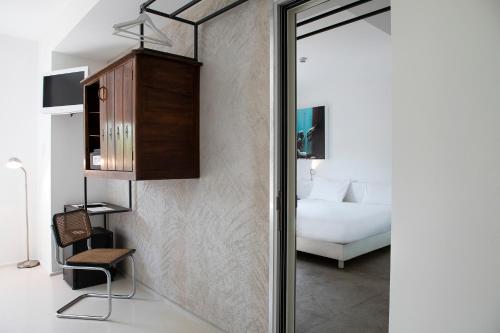 a room with a bed and a chair and a mirror at Aiden by Best Western JHD Dunant Hotel in Castiglione delle Stiviere