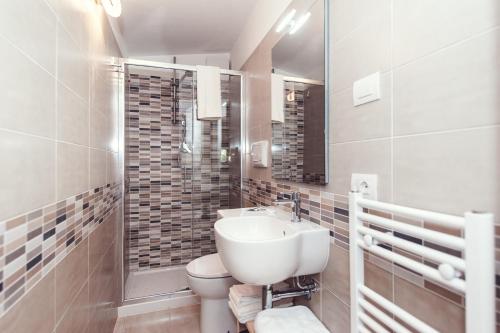 a white bathroom with a sink and a toilet at Luccainn in Lucca