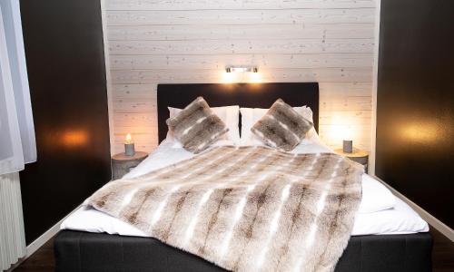 a bed with a blanket and two pillows on it at Sure Hotel by Best Western Algen in Östersund