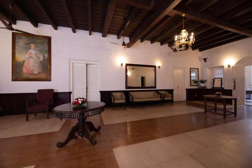 a large room with a table and a painting on the wall at Dutch Bungalow in Cochin