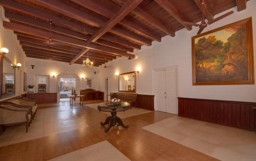 a living room with a painting on the wall and a table at Dutch Bungalow in Cochin