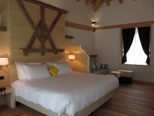 a bedroom with a large white bed and two windows at Hotel Alla Posta in Saint Vincent