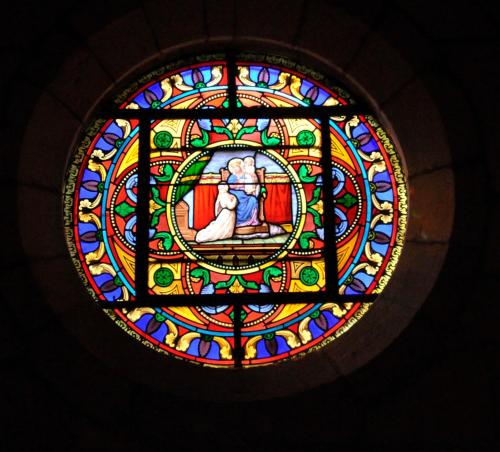 a stained glass window with an image of aoration of theorationvenant at Le Passage in La Charité-sur-Loire