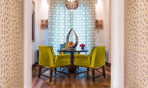 a dining room table with two chairs and a mirror at Banana Island Resort Doha by Anantara in Doha