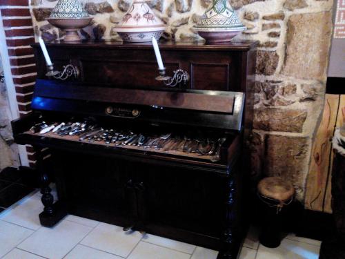an old piano with three vases on top of it at Marie-Claire la grillade in Briare